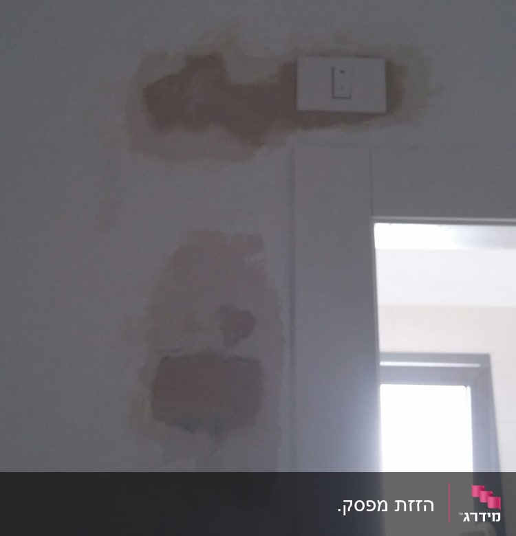 שקע חשמל בקיר עם תיקוני טיח סביבו